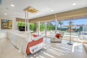 a living room with white furniture and large windows at Traviata in Cap Blanc