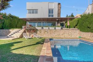 a house with a swimming pool in the yard at Traviata in Cap Blanc