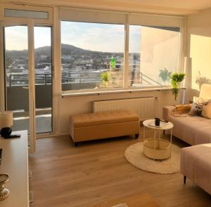a living room with a couch and a large window at Über den Dächern von Aachen in Aachen
