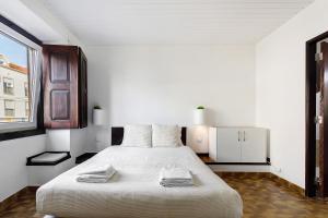 a white bedroom with a large bed and a window at Oasis de Ferrel in Ferrel