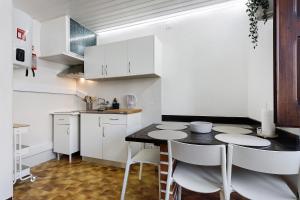a kitchen with white cabinets and a black table and chairs at Oasis de Ferrel in Ferrel