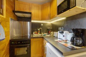 a kitchen with wooden cabinets and a counter top at Les Airelles 32 in Villarodin-Bourget +15 photos