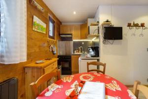 a small kitchen with a table with a red table cloth at Les Airelles 32 in Villarodin-Bourget