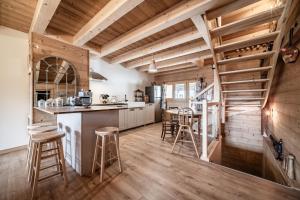 a kitchen with wooden ceilings and wooden stools at Le Chat Perché in Bernex +29 photos