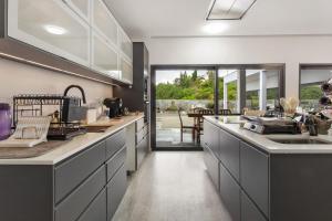 a kitchen with white cabinets and a counter top at Paraiso Madeira - Suites in Gaula