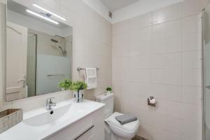 a white bathroom with a sink and a toilet at Seaview las Americas in Adeje +21 photos
