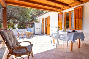 a patio with chairs and a table and a refrigerator at Casa con terrazza nella Pineta in Codaruina