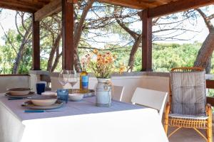 a table with food and flowers on a porch at Casa con terrazza nella Pineta in Codaruina