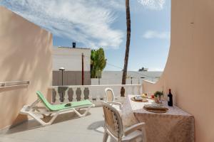 a patio with a table and chairs on a balcony at Seaview las Americas in Adeje