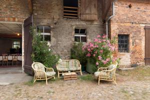 a group of chairs and flowers in front of a brick building at Gästehaus Schlamau19 in Schlamau