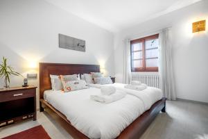 a bedroom with a large bed with white sheets at Casa del Puerto in Port de Soller
