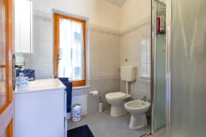 a bathroom with a toilet and a sink and a shower at Casa con terrazza nella Pineta in Codaruina