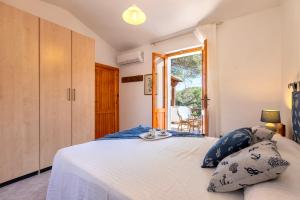a bedroom with a bed with blue pillows at Casa con terrazza nella Pineta in Codaruina