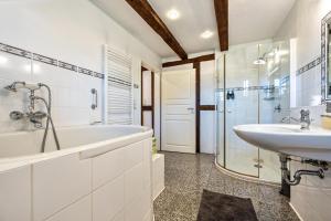 a bathroom with a tub and a sink and a shower at Ferienwohnung Juttashof in Camin +19 photos