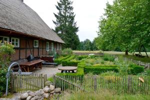 a garden in front of a house with a wooden fence at Ferienwohnung Juttashof in Camin
