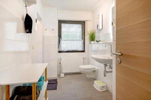 a white bathroom with a toilet and a sink at Rheinferien in Kamp-Bornhofen +17 photos