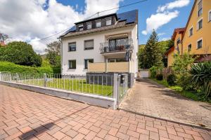 a white house with a fence in front of it at Rheinferien in Kamp-Bornhofen