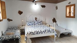 a bedroom with a white bed and a bed and a chair at Hogar vacacional Maya in Santa Maria de Guia de Gran Canaria
