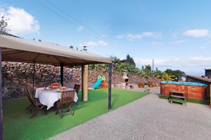 a table and chairs under a pavilion with a playground at Hogar vacacional Maya in Santa Maria de Guia de Gran Canaria