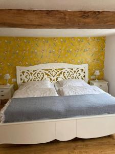 a bedroom with a white bed with yellow wallpaper at Ferienhaus bei Juste in Schotten