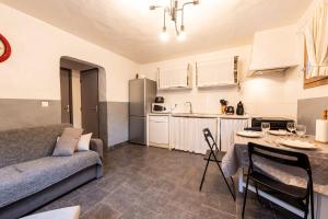 a living room with a couch and a kitchen at Joli Appartement Sur Le Bois in Aigueblanche