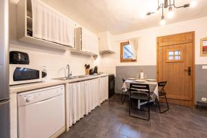 a kitchen with a table and a counter top at Joli Appartement Sur Le Bois in Aigueblanche +13 photos
