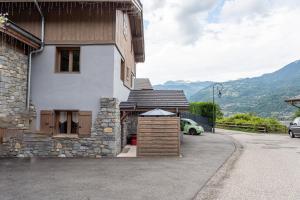 a building with a clock on the side of it at Joli Appartement Sur Le Bois in Aigueblanche