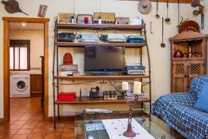 a living room with a tv on a shelf at Casa Rural El Barranco in Mombeltrán