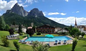 a resort with a swimming pool in front of a mountain at Residence Nussbaumer in Siusi