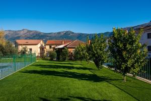a yard with trees and houses with mountains in the background at Casa Rural El Barranco in Mombeltrán