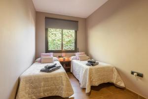 two beds in a room with a window at Casa Lourdes in Canyelles +15 photos