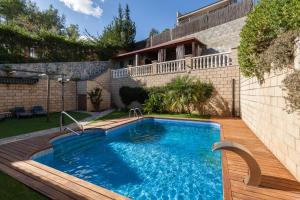 a swimming pool in a yard next to a house at Casa Lourdes in Canyelles