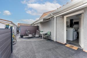 a patio with a table and chairs and a garage at Studio chez Brigitte à Audenge in Audenge