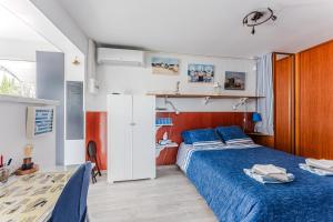 a bedroom with a blue bed and a desk at Studio chez Brigitte à Audenge in Audenge