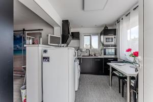 a small kitchen with a refrigerator and a table at Studio chez Brigitte à Audenge in Audenge