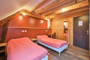 two beds in a room with wooden walls at Gite Sappey Chartreuse in Le Sappey-en-Chartreuse