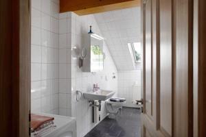 a white bathroom with a sink and a toilet at Gutshaus am Teich in Neukloster +21 photos