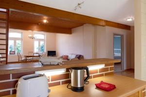a kitchen and living room with a toaster on a counter at Gutshaus am Teich in Neukloster