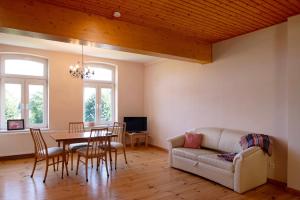 a living room with a table and a couch at Gutshaus am Teich in Neukloster