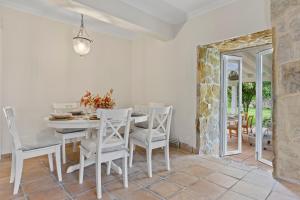 a white dining room with a white table and chairs at La Casuca del Músico in Novales