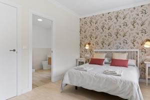 a bedroom with a white bed with red pillows at La Casuca del Músico in Novales