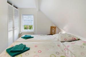 a bedroom with a bed with green towels on it at Ferienwohnungen Schmitz in Wangerland