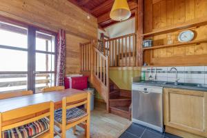 a kitchen with a table and a sink in a cabin at Chalet le Regain in Villard-Reculas