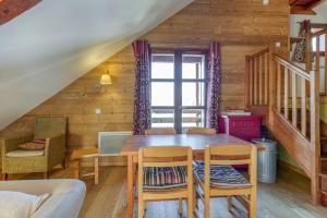 a dining room with a wooden table and chairs at Chalet le Regain in Villard-Reculas