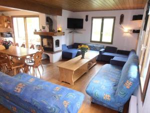 a living room with a blue couch and a table at Chalet St Victoire - Les Orres in Les Orres
