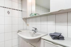 a white bathroom with a sink and a mirror at Ferienwohnung zum Pavillon in Mühlenbach +21 photos