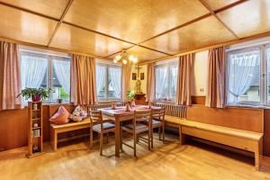 a dining room with a table and chairs and windows at Ferienwohnung zum Pavillon in Mühlenbach
