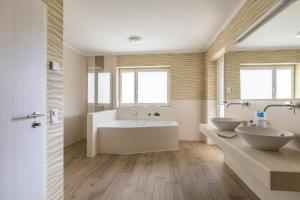 a bathroom with two sinks and a tub at Ferienhaus Manni Eg in Büsum +21 photos