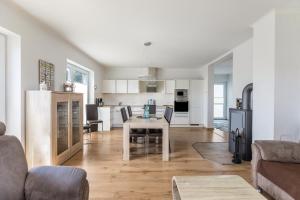 a kitchen and living room with a table and a refrigerator at Ferienhaus Manni Eg in Büsum