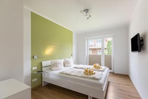 a bedroom with a bed with a green wall at Ferienhaus Manni Eg in Büsum